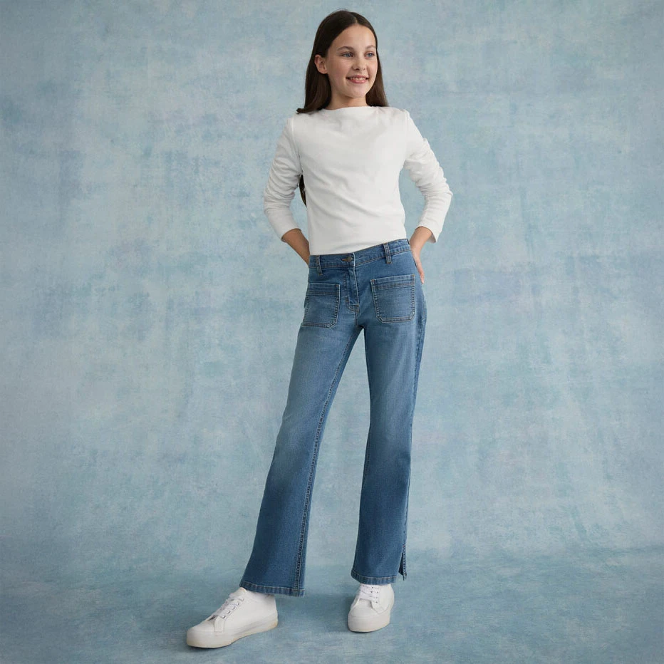 Biela blúzka v kombinácii so skinny džínsami a bielymi topánkami.