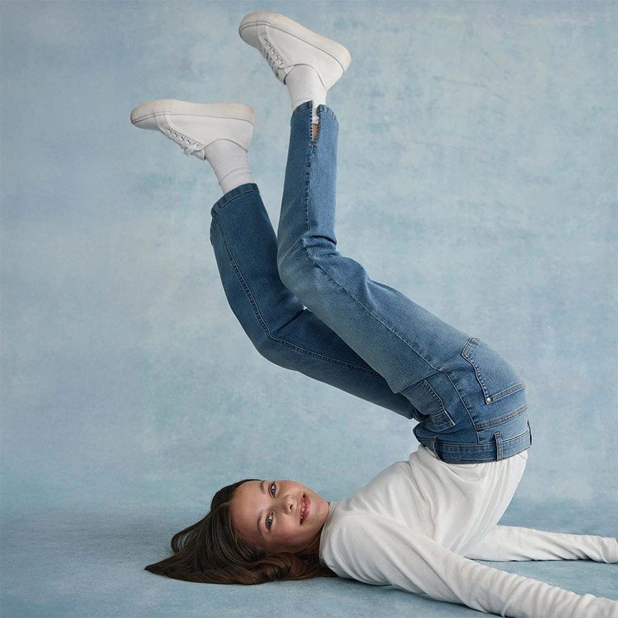 Biela blúzka v kombinácii so skinny džínsami a bielymi topánkami.