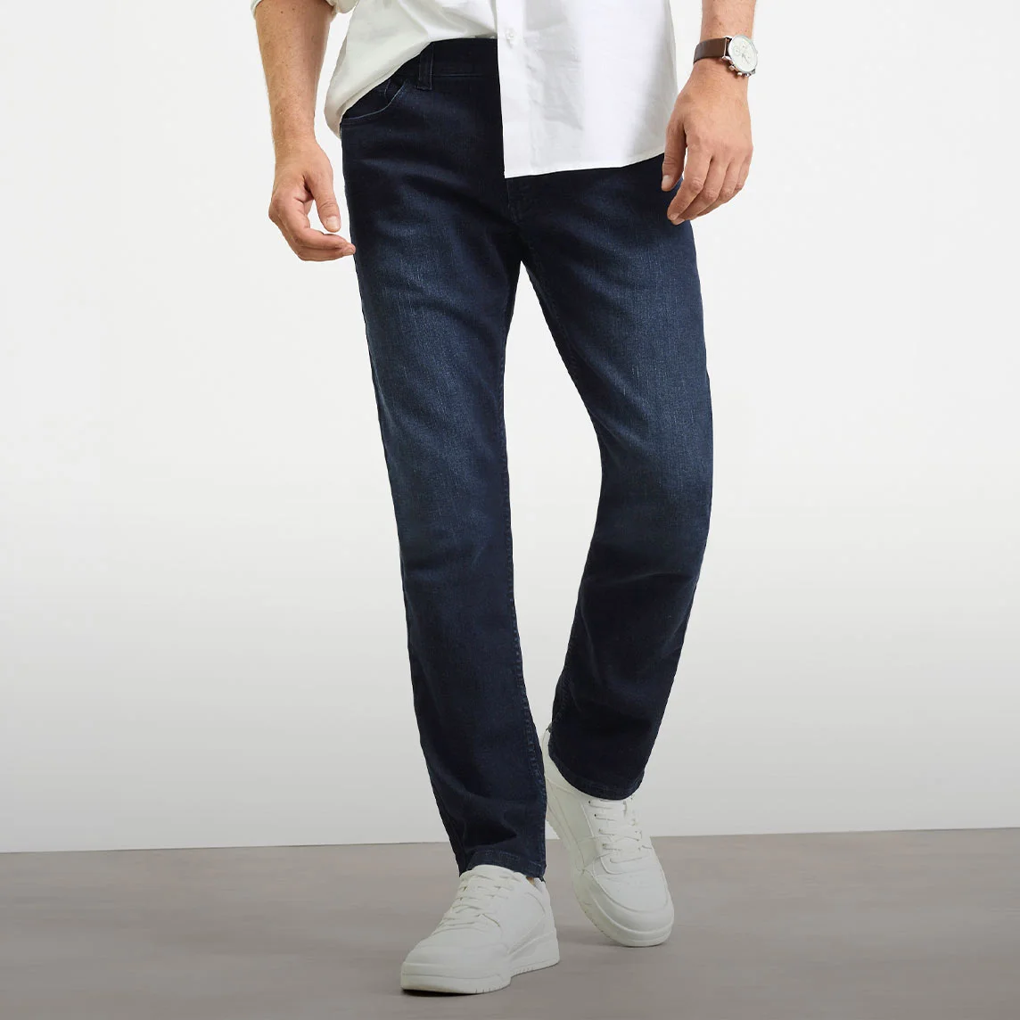 Biela košeľa, tmavé džínsy strihu Slim Fit a biele tenisky.