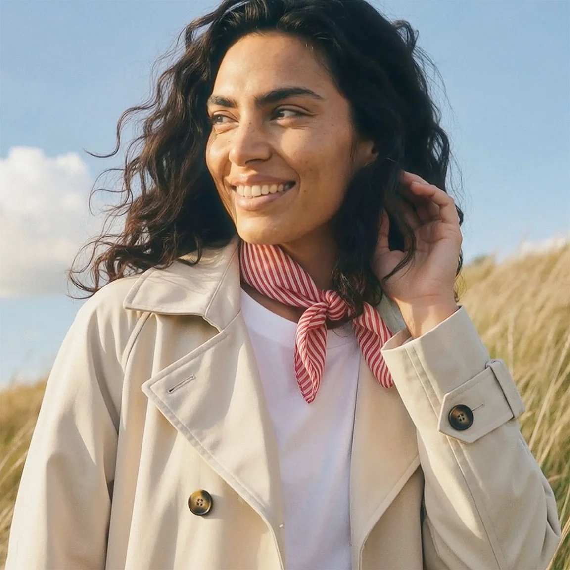 Béžový trenčkot s bielym topom pod ním.